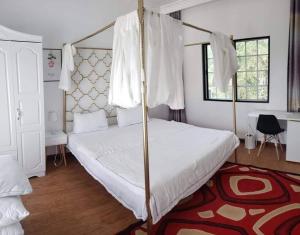 - une chambre avec un lit à baldaquin et un tapis rouge dans l'établissement Summer Stay, à Garapan