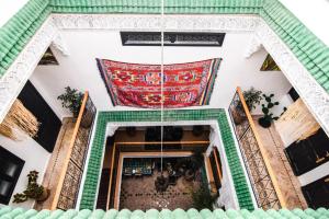 Blick auf ein Gebäude mit einem Teppich an der Wand in der Unterkunft Riad Vis Ta Vie in Marrakesch