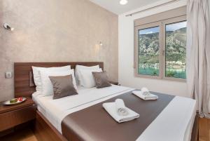 a bedroom with a large bed with a window at De Lux Apartments Sirena in Kotor