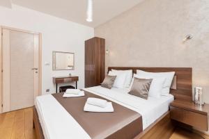 a bedroom with a large bed with two towels on it at De Lux Apartments Sirena in Kotor