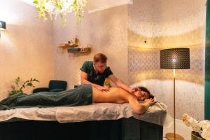 une femme recevant un massage d'un homme sur un lit dans l'établissement Hotel Verde Montana Wellness & Spa, à Kudowa-Zdrój