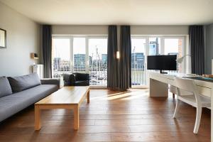 - un salon avec un canapé et une table dans l'établissement Im-Jaich Boardinghouse Bremerhaven, à Bremerhaven