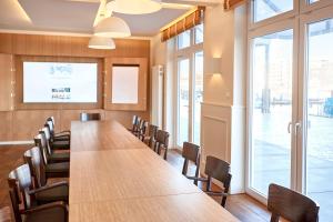 une salle de conférence avec une grande table et des chaises dans l'établissement Im-Jaich Boardinghouse Bremerhaven, à Bremerhaven