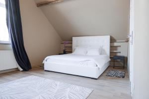 1 dormitorio con cama blanca y ventana en DUPLEX STYLE NEW-YORKAIS !, en Bruselas