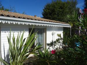 ein weißes Haus mit Pflanzen davor in der Unterkunft Cabane Blanche in Andernos-les-Bains