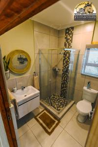 a bathroom with a shower and a sink and a toilet at Pumbaa Wildlife Park & Accommodation in Nelspruit