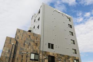 un grand bâtiment blanc au-dessus d'un bâtiment dans l'établissement KNOWS HOTEL, à Numazu