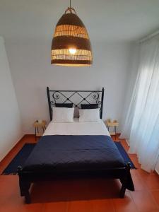 um quarto com uma cama e um lustre em Porta Reguengos - Apartamento moderno Alentejo central em Reguengos de Monsaraz