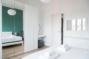 a white bedroom with a bed and a mirror at YouHosty - 25 Aprile 5 in Milan