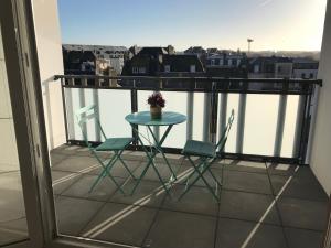 d'une petite table et de deux chaises sur un balcon. dans l'établissement APPARTEMENT NEUF ET BIEN SITUE AVEC UN CLASSEMENT, à Saint-Malo