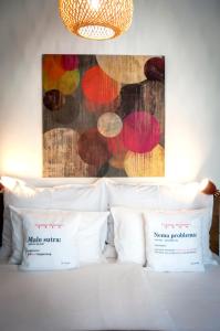 uma cama com almofadas brancas e um quadro na parede em bed&breakfast Bohemian em Rovinj