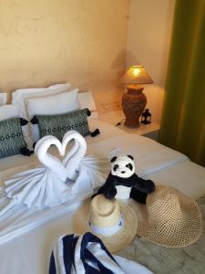 Una cama con un oso panda de peluche y un sombrero. en Hotel Villa Maya, en Saint-Tropez