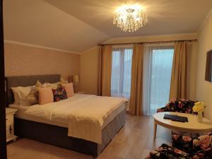 um quarto com uma cama grande e um lustre em Villa Boutique Alina em Deva