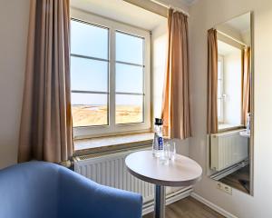 um quarto com uma mesa e uma janela em Nordsee-Hotel Arlau-Schleuse em Husum