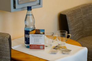 Una botella de agua y dos vasos en una mesa. en Hotel Zur Mühle, en Kappeln