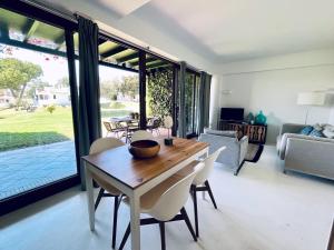 - un salon avec une table et des chaises en bois dans l'établissement Beach House Pedras D'el Rei, à Santa Luzia