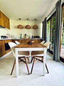 une salle à manger avec une table et des chaises blanches dans l'établissement Beach House Pedras D'el Rei, à Santa Luzia