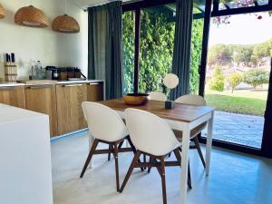 - une cuisine avec une table en bois et des chaises blanches dans l'établissement Beach House Pedras D'el Rei, à Santa Luzia