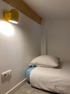 um quarto com uma cama com uma luz na parede em Les Suites de La Villa Mouneyra em Bordéus