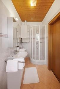 a bathroom with a sink and a shower at Goldengel Ferienwohnung im Herzen Kalterns mit einer Terasse zum verlieben in Caldaro