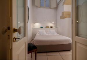 een kleine slaapkamer met een bed met witte lakens bij B&B Corte Dei Romiti - Lecce Selection in Lecce