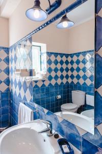 een blauw betegelde badkamer met een wastafel en een toilet bij Quinta Da Torre - Óbidos Country House in Óbidos