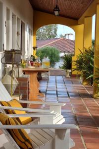 een patio met een tafel en stoelen op een veranda bij Quinta Da Torre - Óbidos Country House in Óbidos