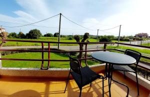 einen Balkon mit einem Tisch und Stühlen sowie Blick auf ein Feld in der Unterkunft EL RINCON DE AJO in Ajo