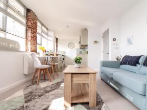 a living room with a blue couch and a table at Lighthouse Lofts - Godrevy in Camborne