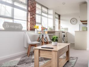 a kitchen with a wooden table in a room at Lighthouse Lofts - Godrevy in Camborne