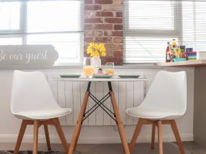 two white chairs and a table with drinks on it at Lighthouse Lofts - Godrevy in Camborne