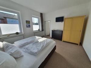 a bedroom with two beds and a dresser and a television at Gästehaus bed & kitchen in Schleswig