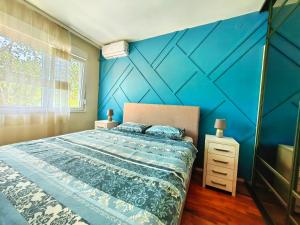 um quarto com uma parede em tons de azul e uma cama em Luxury apartment Podgorica em Podgorica