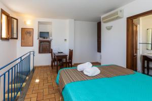 a bedroom with a bed and a table with a desk at Residenza d'Epoca Pietra Di Ponente in Ciampino