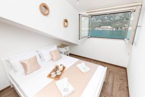 a bedroom with a white bed with a window at De Lux Apartments Sirena in Kotor