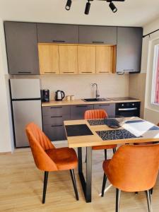 uma cozinha com uma mesa e cadeiras e um frigorífico em OM Apartment em Podgorica