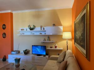 a living room with a couch and a tv at City Center Apartment in Shkoder in Shkodër