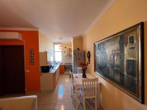 a kitchen and dining room with a painting on the wall at City Center Apartment in Shkoder in Shkodër