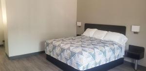 um quarto com uma cama com um edredão branco e azul em Motel 6 Mobile, AL - Airport Blvd em Mobile