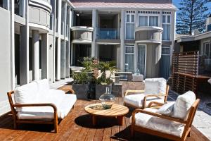 - un ensemble de chaises et d'une table sur une terrasse dans l'établissement Swakopmund Luxury Suites, à Swakopmund