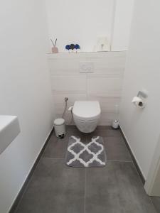 ein Badezimmer mit einem WC und einem Teppich auf dem Boden in der Unterkunft Strassen - 2 bed designer flat in Strassen