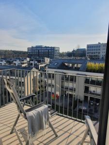 einen Stuhl auf einem Balkon mit Stadtblick in der Unterkunft Strassen - 2 bed designer flat in Strassen