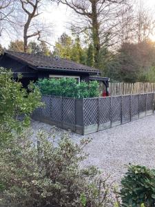 einen Zaun mit einem Garten vor einem Gebäude in der Unterkunft Chambre d'HÔTE Maison De L'amitié in Lanton