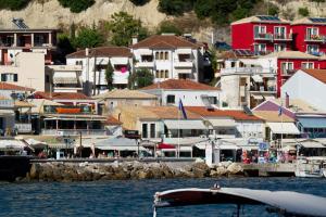 een boot in het water naast een groep gebouwen bij Olympic Apartments in Parga