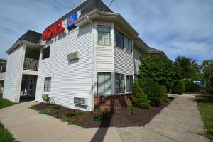 a white building with a sign on the side of it at Motel 6-Wethersfield, CT - Hartford in Wethersfield