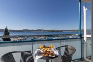 uma mesa com um prato de comida numa varanda em Hotel Kornati em Biograd na Moru