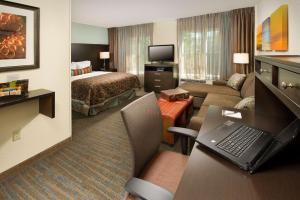 a hotel room with a bed and a living room at Sonesta ES Suites Toronto Markham in Markham