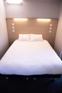 a large white bed with a wooden head board at The People - Tours in Tours