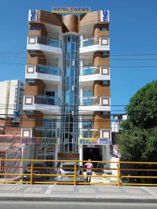 due persone in piedi di fronte a un edificio di Hotel Caribe Real Inn a Santa Marta