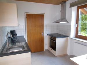 una cucina con lavandino e porta in legno di Ferienwohnung Familie Bauer a Kelheim